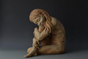 In the Moment; bronze sculpture, edition of 25; 18"H x 20"W x 17"D. A young girl sits, musing, lost in reverie, she tunes out all else. In the simplicity of the moment, all is well in her serene world.