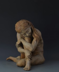 In the Moment; bronze sculpture, edition of 25; 18"H x 20"W x 17"D. A young girl sits, musing, lost in reverie, she tunes out all else. In the simplicity of the moment, all is well in her serene world.