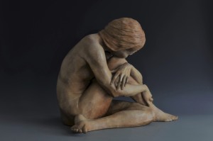 In the Moment; bronze sculpture, edition of 25; 18"H x 20"W x 17"D. A young girl sits, musing, lost in reverie, and tunes out all else. In the simplicity of the moment, all is well in her serene world.