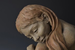 In the Moment; bronze sculpture, edition of 25; 18"H x 20"W x 17"D. A young girl sits, musing, lost in reverie, and tunes out all else. In the simplicity of the moment, all is well in her serene world.